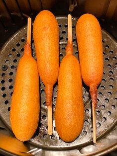 four pieces of food sitting on top of a fryer grate with toothpicks sticking out of them