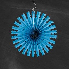 a blue paper fan hanging from a string