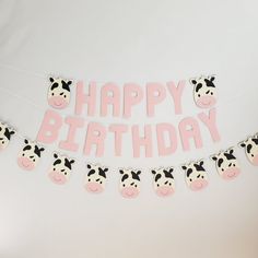 a happy birthday banner with pink and black cow decorations