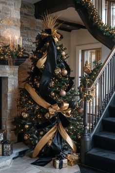 Grand Christmas tree and fireplace adorned with black gold and silver christmas decor Christmas Tree Black Ribbon, Black Xmas Tree Decorating Ideas, Stairway Decorating Christmas, Gold And Silver Christmas Decor, Gold Christmas Tree Decor, Silver Christmas Decor