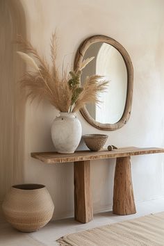 a table with a mirror and vase on it