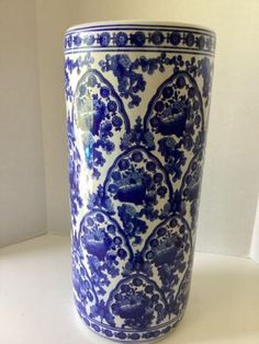 a large blue and white vase sitting on top of a table next to a wall