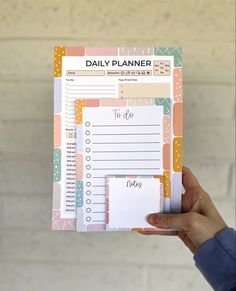 a person holding up a daily planner in their hand