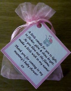 a pink ribbon tied around a tag on a wooden table with words written in it