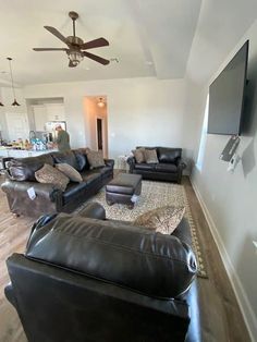 a living room filled with furniture and a flat screen tv mounted on the wall above it