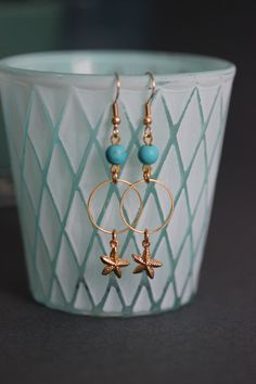 Lovely earrings with natural turquoise stone 6 mm beads, gold tone hoops, seafish charms and gold tone earring hooks. Earring hooks are from nickel free and lead free metal. Perfect for everyday wear! *The total lenght of earrings is about 59 mm including the earring hooks. Other earrings of my shop you can see here: https://www.etsy.com/shop/NaTavelli?section_id=13757927 Thanks for visit. Gold Metal Jewelry With Starfish Charm, Gold Jewelry With Starfish Charm, Handmade Ocean-inspired Gold Earrings, Gold Pierced Hoop Earrings For Beach, Nickel Free Gold Ocean-inspired Earrings, Nickel Free Ocean-inspired Gold Earrings, Gold Dangle Earrings For Beach, Ocean-inspired Gold Wire Wrapped Jewelry, Gold Starfish Charm Drop Earrings