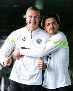 two soccer players are hugging each other while they pose for the camera with their arms around each other