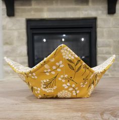 a paper boat sitting on top of a wooden table next to a fireplace in a living room