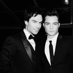 two young men in tuxedos posing for the camera