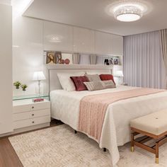 a bedroom with a large bed and white furniture