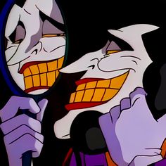 the joker is looking in the mirror with his mouth open and tongue out as if he's trying to see himself in the mirror