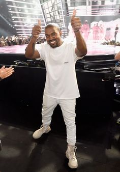 a man standing in front of a stage giving the thumbs up