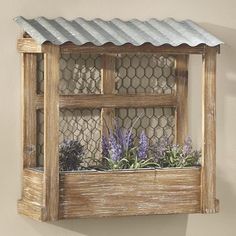 a wooden window box with plants in it and a chicken wire fence around the top