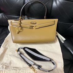 Tory Burch Lee Radziwill Cat Eye Bag Height: 5.3" (13.5cm); Length: 9.7" (24.5cm); Depth: 4.5" (11.5cm) Luxury Tan Handheld Bag, High-end Tan Satchel With Top Carry Handle, High-end Tan Bag With Detachable Strap, High-end Tan Top Handle Shoulder Bag, High-end Tan Bags For Office, High-end Tan Office Bags, High-end Tan Shoulder Bag With Removable Pouch, Tan Handheld Bag With Detachable Handle, High-end Tan Top Handle Satchel