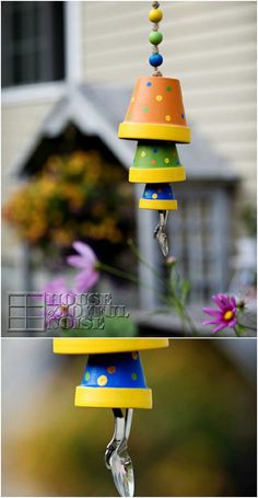 a colorful bird feeder hanging from the side of a house next to a purple flower