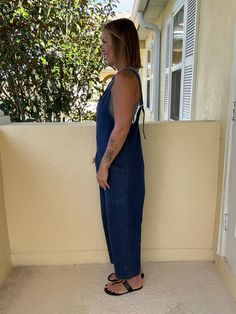 We love a good dupe! This super fun denim jumpsuit is 77%COTTON 13%POLYESTER 10%VISCOSE medium weight with no stretch but is is super roomy so no need for sizing up! Featuring a deep v neckline, deep front patch pockets, and adjustable straps. The legs can also be rolled for another look. Pair with anything from a bandeau to a long sleeve...this item will be wearable all year long! Model is 5'5" 32B size 6 wearing a small Fitted Casual Denim Jumpsuit With V-neck, Denim Blue V-neck Jumpsuits And Rompers, Dark Wash High Rise Jumpsuits And Rompers With Pockets, High Rise Dark Wash Jumpsuits And Rompers With Pockets, High Rise Dark Wash Jumpsuits With Pockets, Casual Dark Wash Bib Front Overalls, Casual Medium Wash Full-length Overalls, Cotton Denim V-neck Jumpsuit, Casual Full-length Denim Jumpsuit