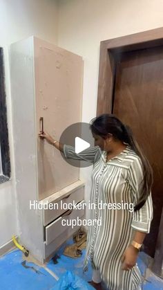 a woman standing in front of a white refrigerator freezer next to a wooden door