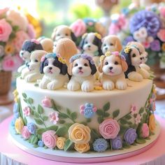 a cake decorated with dogs and flowers on top of a pink tableclothed table