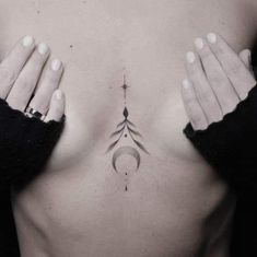 a woman's chest with her hands on the top of her stomach and an arrow tattoo