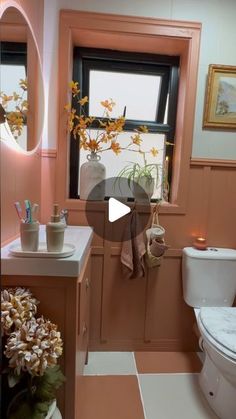 a bathroom with a toilet, sink and window in it's centerpieces