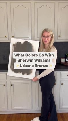 a woman holding up a sign with the words what colors go with sherylin williams and urban bronze