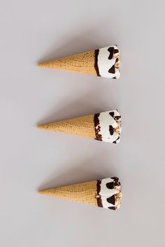 three ice cream cones with toppings on them