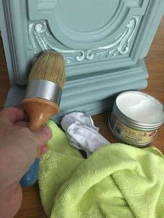 a person is holding a paint brush near some other items