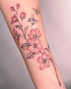 a woman's arm with flowers on it and a bee flying over the flower