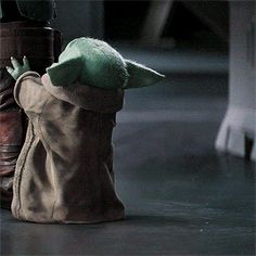 the baby yoda doll is next to an old pair of shoes