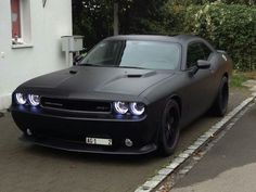 a black car is parked on the side of the road