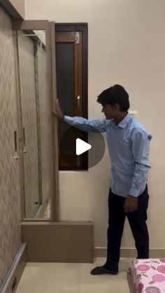 a man is standing in front of a shower door and pointing at the glass on it