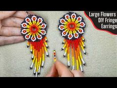 the beaded earrings are being held by someone