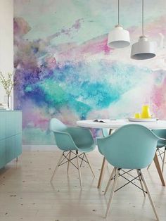 a dining room table with four chairs in front of a colorful wall mural on the wall