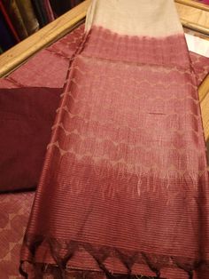 An elegant dyed maroon colour pure tussar (with silkmark) kurta and dupatta fabric set with weaving in off white threads. The pant fabric is cotton. The kurta is tie and dyed in off white and maroon colours.  The length of kurta, dupatta, and pant fabric is 2.5 meters each.  This product must be dry cleaned.      The photos have been captured in natural day light. However, there might be slight differences in the actual colour of the product due to lights and colour settings.     This product ma Brown Raw Silk Dupatta With Zari Work, Brown Raw Silk Dupatta For Festivals, Brown Handloom Dupatta For Diwali, Brown Handloom Chanderi Dupatta, Brown Chanderi Dupatta With Traditional Patterns, Brown Chanderi Handloom Dupatta, Brown Silk Dupatta With Zari Work, Handloom Chanderi Brown Dupatta, Traditional Drape Brown Raw Silk Dupatta