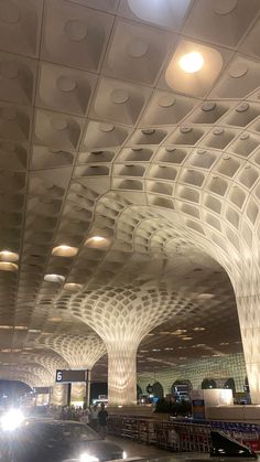 the interior of an airport with many lights on and ceiling made out of white circles