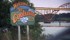 the welcome sign to coolsville is in front of a bridge over water and trees