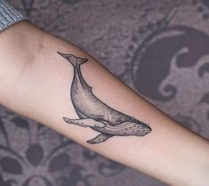 a whale tattoo on the left arm