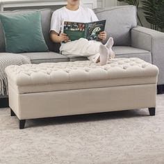 a boy sitting on a couch reading a book