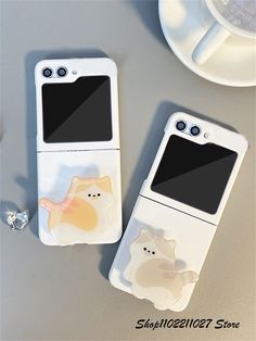 two cell phones sitting next to each other on top of a table with an animal sticker on them