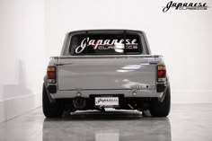 the back end of a silver truck with japanese lettering on it