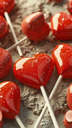 there are many heart shaped lollipops on the table