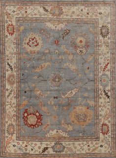 a blue and beige rug with an ornate design on the center, surrounded by flowers