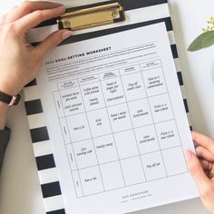 a person holding a clipboard with a goal setting worksheet on it