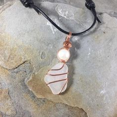 This Beautiful genuine Sea glass necklace is truly unique. Made from white frosted Lake Erie Beach Glass naturally tumbled by the waves, each piece of Beach Glass is its own unique shape, and hand chosen for your necklace.  It is wire-wrapped by hand with pure copper wire and accented with a genuine white freshwater pearl. The beautiful pendant is then hung on a adjustable leather cord necklace that can be worn at 14 inches or as long as 26 inches. I take great care in the creation of each and e White Glass Necklaces For Beach, White Glass Beach Necklace, White Glass Necklaces For The Beach, Adjustable Wire Wrapped Necklace In Recycled Glass, Adjustable Wire Wrapped Necklaces In Recycled Glass, White Recycled Glass Jewelry For The Beach, White Glass Beach Jewelry, White Sea Glass Necklace As A Gift, White Sea Glass Necklace For Gift