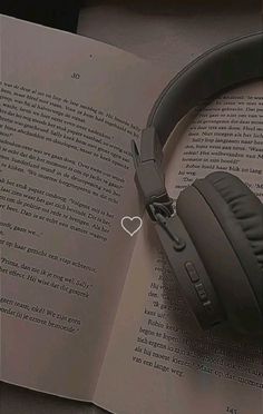 an open book with headphones on top of it