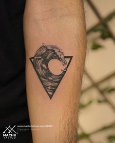 a man's arm with a black and white wave tattoo on the left forearm