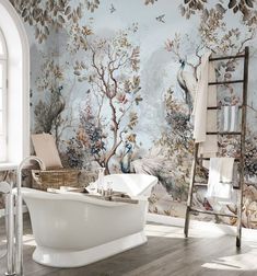 a bathroom with a large mural on the wall and a claw foot tub in front of it