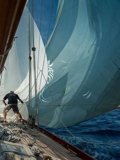 a man standing on the deck of a sailboat