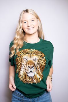 Lion Roar | Women's Sequin Design Tee (Green) Hey Lion Fans! This must-have tee features a stunning sequin embroidery design that will make you stand out from the crowd. If you are a French Settlement, or Southeastern Lion, this would be great for your team! *Size Chart available for size reference in the images* Material: 93% Cotton- 7% Spandex Features: Sequin Embroidery Please Note: We do not re-stock the same design & tee shirt color. Once this item is no longer available, we will not restoc Lion Roar, Louisiana Tech, Custom Trucker Hats, Everyday Purse, Sequin Embroidery, Sequin Design, Beaded Headband, Tassel Bracelet, Tee Shirt Dress