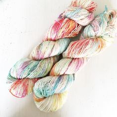 several skeins of multicolored yarn sitting on top of a white surface